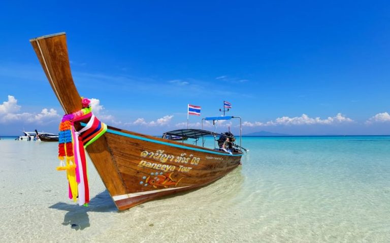Phi Phi longtail boat tour. Snorkeling adventure on a private boat in Thailand's clear turquoise water. Gay travel advice for island hopping.