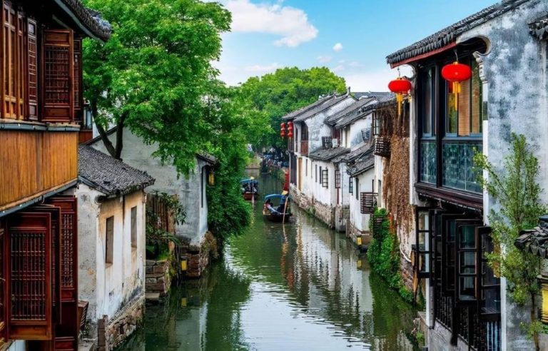 Zhujiajiao Water Town escape from Shanghai. Canal view with boats, traditional buildings, red lanterns. Gay travel adventure.