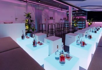 Hanoi's R7 Bar: Stylish interior with illuminated cube tables, bottles, and glasses. A modern gay bar for travel advice seekers.