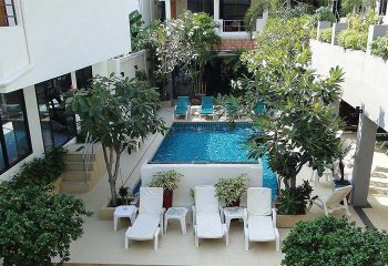 Sansuk Gay Sauna Pattaya pool area. Gay travel advice for men's sauna, with lounge chairs and lush tropical foliage.