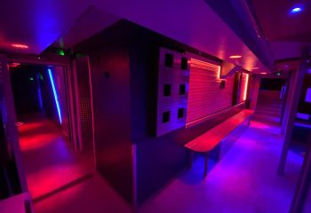 Saunawerk Frankfurt interior. Gay sauna with blue and red neon lights, lockers, and benches. A modern, industrial design for gay men's travel.