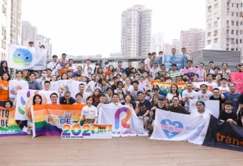 ShanghaiPRIDE group photo. Gay men travel to Shanghai. LGBTQ+ community members with rainbow flags, celebrating diversity & inclusion.
