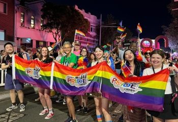 Shanghai Pride parade at night. People hold a rainbow banner with Pride on it. Gay travel destination in China.