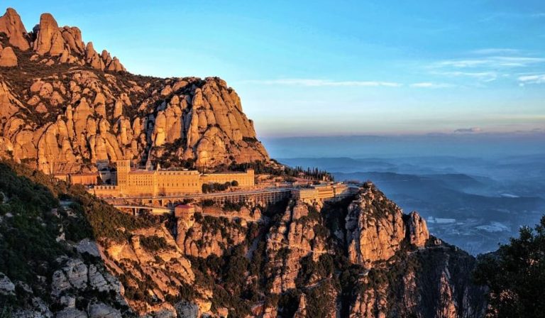 Montserrat Monastery, Spain. Sacred gay travel views of the mountaintop abbey near Sitges. Seaside cruise destination for gay men.
