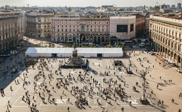 Milan's Duomo rooftop view: Piazza del Duomo, bustling with people. Cathedral tour with VIP access offers sky-high views for gay travelers.