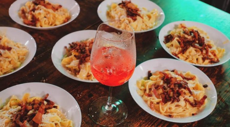 Spritz and Spaghetti: Plates of pasta with bacon surround a spritz cocktail. Rome's boozy pasta-making party for gay men's travel advice.
