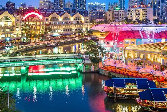 Singapore's Starry Night Tour: River cruise with light shows. Colorful buildings reflect on the water. Gay travel destination.