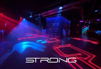 STRONG Gay Club in Madrid: Interior view with neon lights, container, and stage lighting. A popular gay cruise club destination.