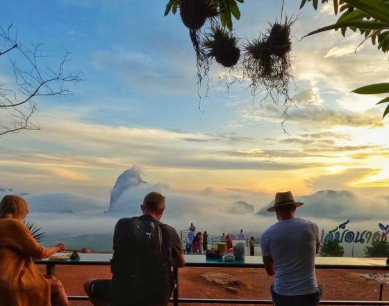 Gay travelers enjoy sunrise views in Phangnga Bay, James Bond Island. LGBTQ-friendly private longtail boat adventure in Thailand.