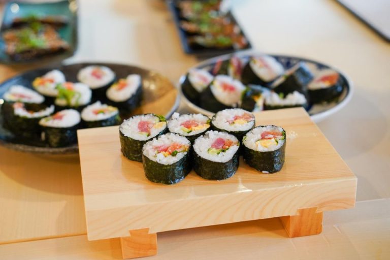 Sushi rolls on a wooden board. Japanese cuisine, featuring nori seaweed, rice, tuna, and cucumber. Gay travel food adventure. Sushi.jpg