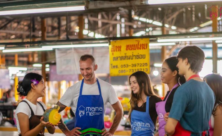 Gay traveler at Thai Cooking Class at Organic Farm Chiang Mai. Group learns Thai bites, smiling. Hanoi tour alternative.