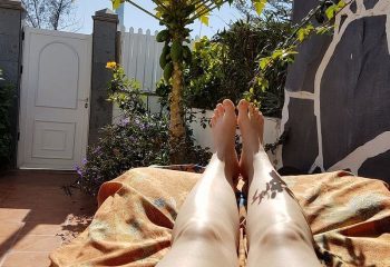 Relaxing in Gran Canaria. Legs of a person on a lounger, enjoying the sun. Gay massage travel destination. Thai Holistic massage.