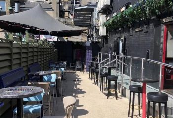 Outdoor seating area at The George Gay Club, Dublin. Tables, chairs, and umbrellas provide a welcoming space for gay travelers.