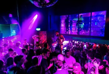 CIRCA The Club: London gay bar scene with go-go boys and dancers. Crowd enjoying the nightlife in a vibrant, energetic atmosphere.