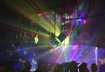 Sydney's TRADE Club: A vibrant gay nightlife spot with colorful laser lights, disco balls, and a lively crowd. Gay travel destination.