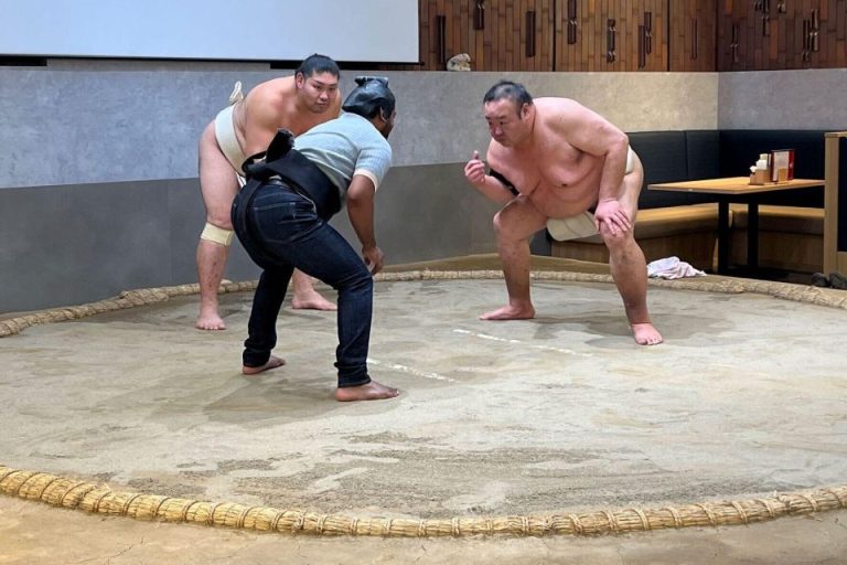 Gay travel: Sumo wrestlers facing off in a ring. Wrestle-Sumo event, possibly related to a ramen tasting tour, showcasing Japanese culture.