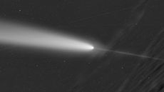 A black and white photo of a comet with a bright tail and a second fainter line coming off of it in the other direction