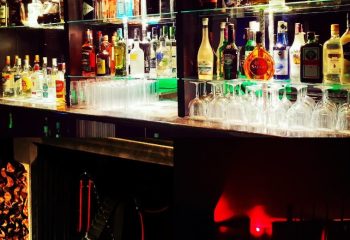 XXL Club Lisbon bar with liquor bottles and glassware. Gay nightlife in Lisbon, Portugal. Popular gay bar for men's travel advice.