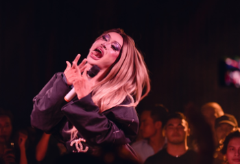 Drag queen at Blue Chilli, Phnom Penh. Gay travel advice: performer with blonde hair, purple eyeshadow, singing into a microphone. Nightlife.