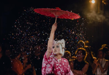 Drag queen with red umbrella in Phnom Penh, Cambodia. Gay travel destination with vibrant nightlife and culture. Blue Chilli bar scene.
