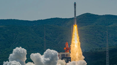 a rocket launching with fire coming from the thruster with mountains in the background.