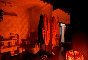 Interior of a spa in Dublin, Ireland. Focus on robes, chair, mirror, and warm lighting. Gay massage travel destination.