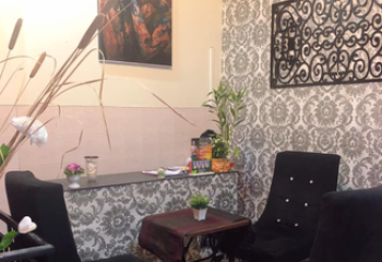 Paradise Massage Phnom Penh interior. Waiting area with chairs, table, and decorative art. Gay travel advice for relaxation and wellness.