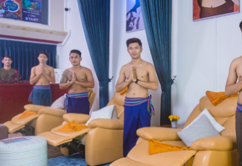 Paradise Massage Phnom Penh: Staff greets guests at a gay-friendly spa. Men in sarongs stand in front of massage chairs.