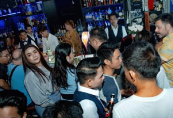 POC Bar, Phnom Penh: A lively, crowded gay bar scene. People are socializing near the bar, enjoying the vibrant atmosphere.