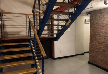 Staircase inside The Boilerhouse gay sauna in Dublin. Blue metal frame, wooden steps and handrail. Gay travel advice.
