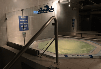 The Boilerhouse Gay Sauna Dublin's hot tub. Steps lead to the pool. A sign reads: Vacate the pool when red light is on. Gay travel advice.